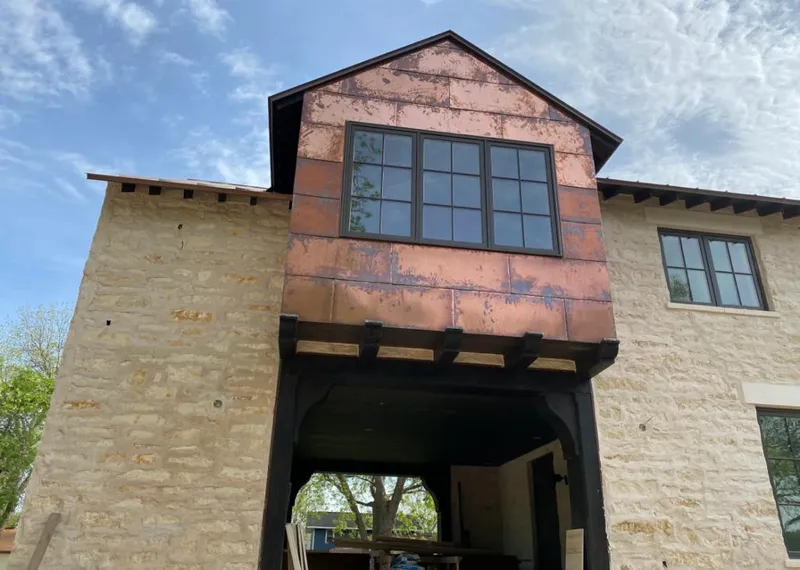Copper metal panel facade on a stone building for Roof Repair in Sand Lake